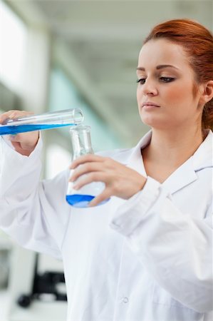 simsearch:400-05670345,k - Portrait of a scientist pouring blue liquid in an Erlenmeyer flask in a laboratory Photographie de stock - Aubaine LD & Abonnement, Code: 400-05670338