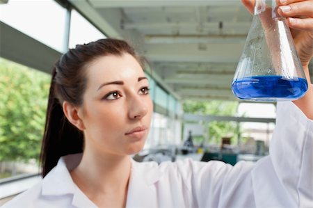 simsearch:400-05670362,k - Brunette looking at a blue liquide in a laboratory Stock Photo - Budget Royalty-Free & Subscription, Code: 400-05670361