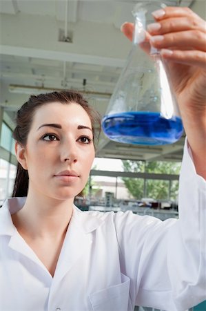 simsearch:400-05670362,k - Portrait of a brunette looking at a blue liquid in a laboratory Stock Photo - Budget Royalty-Free & Subscription, Code: 400-05670363