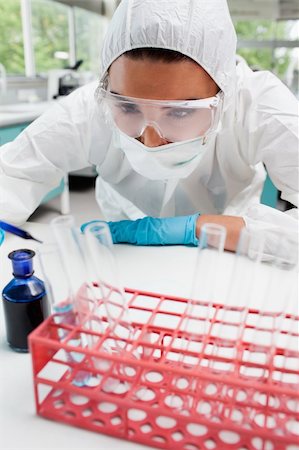 simsearch:400-05670335,k - Portrait of a protected female scientist dropping blue liquid in a test tube in a laboratory Stockbilder - Microstock & Abonnement, Bildnummer: 400-05670488