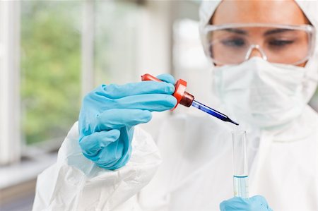 simsearch:400-04576796,k - Protected scientist dropping a liquid in a test tube in a laboratory Fotografie stock - Microstock e Abbonamento, Codice: 400-05670481