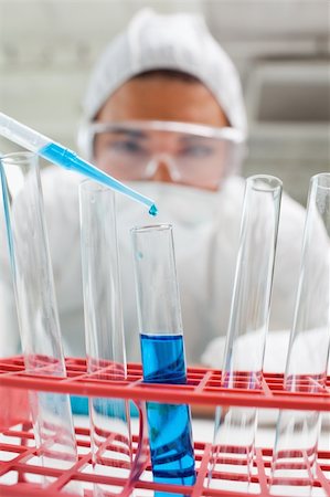 simsearch:400-05669818,k - Portrait of a protected science student dropping blue liquid in a test tube in a laboratory Fotografie stock - Microstock e Abbonamento, Codice: 400-05670497