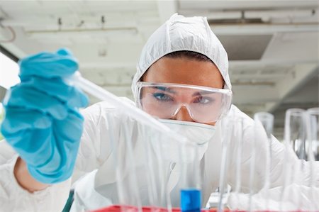 simsearch:400-05669824,k - Close up of a protected science student dropping liquid in a test tube in a laboratory Foto de stock - Royalty-Free Super Valor e Assinatura, Número: 400-05670493