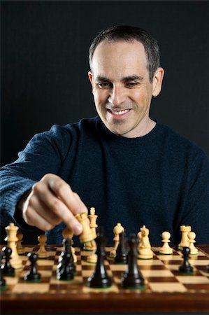 Man moving a chess piece to win the game Stock Photo - Budget Royalty-Free & Subscription, Code: 400-05670551