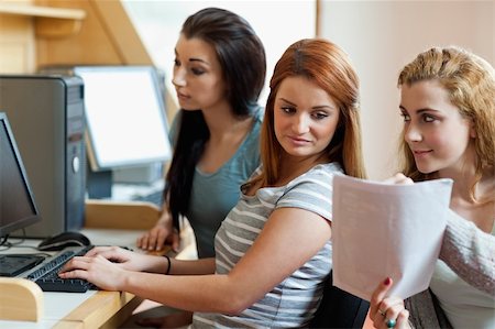 simsearch:400-05684311,k - Smiling student showing her notes to her classmate in an IT room Stock Photo - Budget Royalty-Free & Subscription, Code: 400-05670660