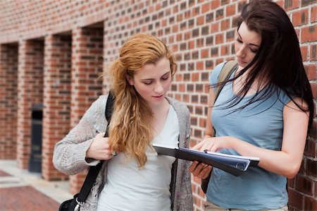 Student showing something to her classmate on a notepad Stock Photo - Budget Royalty-Free & Subscription, Code: 400-05670690