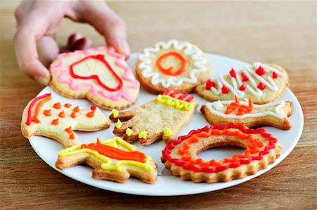simsearch:400-05078153,k - Hand taking cookie from plate of homemade shortbread cookies with icing Fotografie stock - Microstock e Abbonamento, Codice: 400-05670742