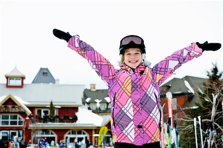 Happy teenage girl with arms raised in ski helmet at winter resort Stock Photo - Budget Royalty-Free & Subscription, Code: 400-05671228