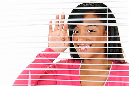 Happy young black woman looking through horizontal venetian blinds Foto de stock - Super Valor sin royalties y Suscripción, Código: 400-05671220