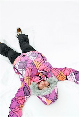 Happy teenage girl making snow angel in winter Stock Photo - Budget Royalty-Free & Subscription, Code: 400-05671232