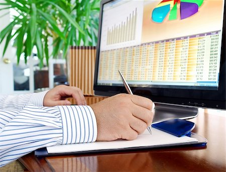 Male hands with pen analyzing  financial data and computer screen with charts. Stock Photo - Budget Royalty-Free & Subscription, Code: 400-05671308