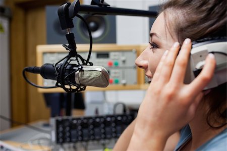 sprecherin - Smiling radio host speaking through a microphone Stockbilder - Microstock & Abonnement, Bildnummer: 400-05672203