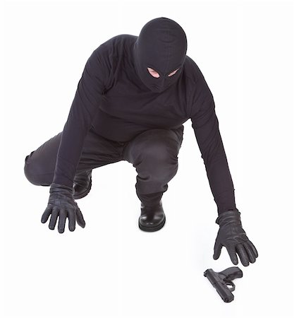 picture of a person wearing a black hat - bandit is trying to recover his weapon on white background Stock Photo - Budget Royalty-Free & Subscription, Code: 400-05672518