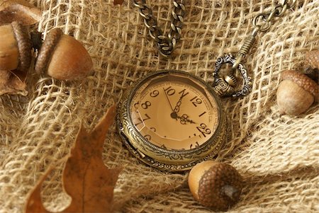 pocket watch - A pocket watch on some burlap with dead oak leaves and acorns for the changing of the autumn season. Stock Photo - Budget Royalty-Free & Subscription, Code: 400-05672918