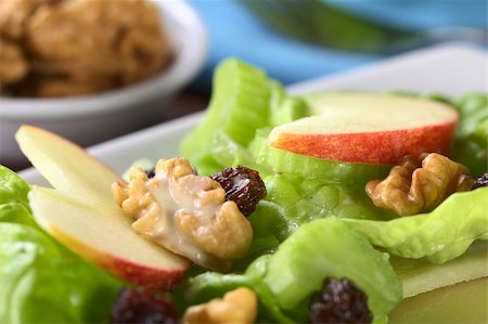 simsearch:400-05673047,k - Fresh home-made delicious Waldorf Salad consisting of lettuce, apple, celery, walnuts, raisins and mayonnaise with walnuts in the back (Selective Focus, Focus on the front of the apple slice on the right) Foto de stock - Royalty-Free Super Valor e Assinatura, Número: 400-05673047
