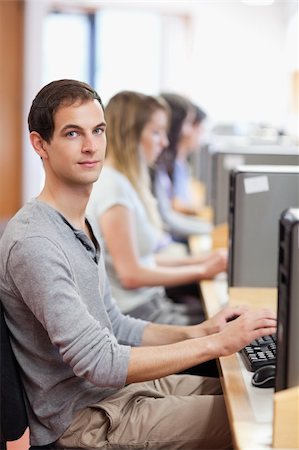 simsearch:400-05684311,k - Portrait of a male student posing with a computer in an IT room Stock Photo - Budget Royalty-Free & Subscription, Code: 400-05684117