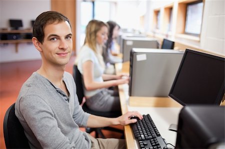 simsearch:400-05684311,k - Portrait of a male student posing with a computer in an IT room Stock Photo - Budget Royalty-Free & Subscription, Code: 400-05684118