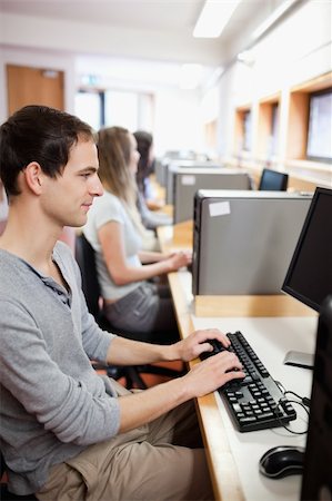 simsearch:400-05684311,k - Serious male student working with a computer in an IT room Stock Photo - Budget Royalty-Free & Subscription, Code: 400-05684122