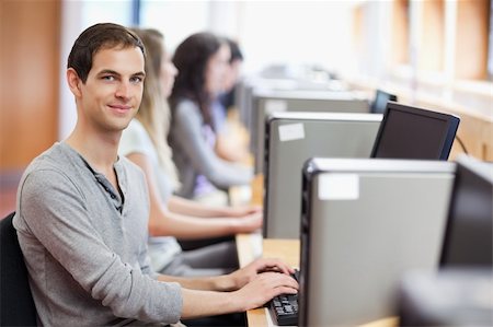 simsearch:400-05684311,k - Smiling fellow students in an IT room with the camera focus on the foreground Stock Photo - Budget Royalty-Free & Subscription, Code: 400-05684132