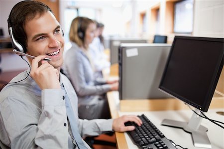 Smiling assistant using a headset in a call center Stock Photo - Budget Royalty-Free & Subscription, Code: 400-05684275