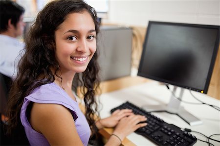 simsearch:400-05684311,k - Smiling brunette student posing with a computer in an IT room Stock Photo - Budget Royalty-Free & Subscription, Code: 400-05684314