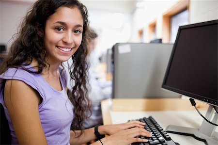 simsearch:400-05684311,k - Cute smiling student with a computer in an IT room Stock Photo - Budget Royalty-Free & Subscription, Code: 400-05684312
