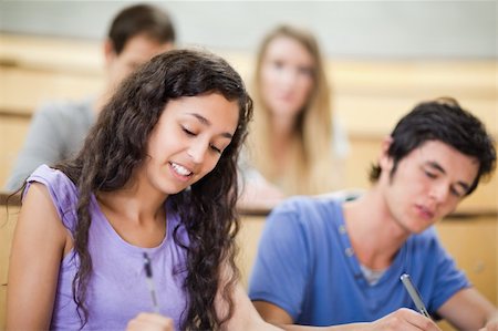 simsearch:400-05684360,k - Smiling students writing in an amphitheater Stock Photo - Budget Royalty-Free & Subscription, Code: 400-05684354