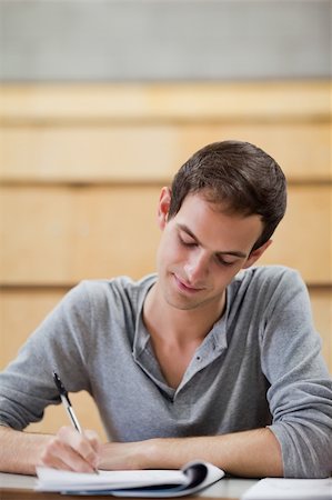 simsearch:400-05684360,k - Portrait of a male student writing on a notepad in an amphitheater Stock Photo - Budget Royalty-Free & Subscription, Code: 400-05684391