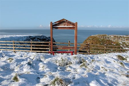 simsearch:400-05684643,k - a seasonal snow frosty covered red bench framed with a sea view and blue cloudy sky background with copy space Photographie de stock - Aubaine LD & Abonnement, Code: 400-05684640