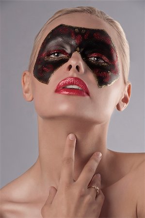 simsearch:400-07776243,k - beauty portrait of a pretty blonde girl with a painted black and red carnival mask on her face and red lipstick Fotografie stock - Microstock e Abbonamento, Codice: 400-05685779