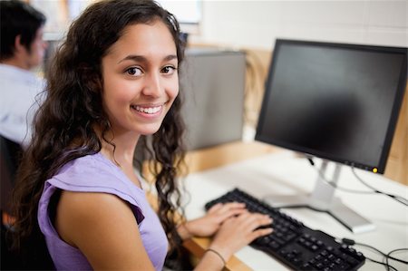 simsearch:400-05684311,k - Smiling brunette student posing with a computer in an IT room Stock Photo - Budget Royalty-Free & Subscription, Code: 400-05681046