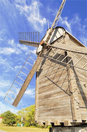fräsen - Old wooden windmill against the blue sky with clouds Stockbilder - Microstock & Abonnement, Bildnummer: 400-05682282