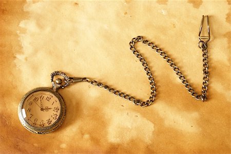 pocket watch - A pocket watch with a chain on a brown background. Photographie de stock - Aubaine LD & Abonnement, Code: 400-05682878