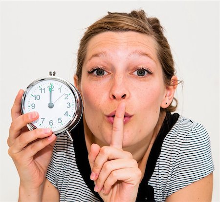 beautiful young woman holding alarm clock and hushing Stock Photo - Budget Royalty-Free & Subscription, Code: 400-05683176