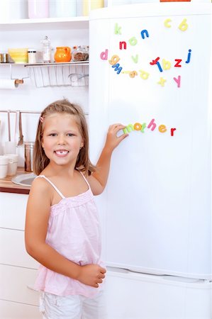 Girl with letter fridge magnets in the kitchen Stock Photo - Budget Royalty-Free & Subscription, Code: 400-05683254
