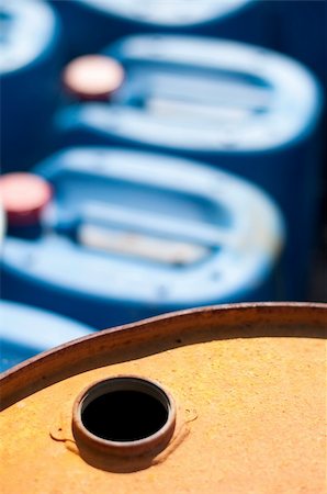 Old colored barrels for oil products. Empty rusted drums and blue canisters Foto de stock - Royalty-Free Super Valor e Assinatura, Número: 400-05683322