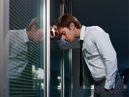store night exterior - young adult italian business man banging his head against a window in office. Horizontal shape, copy space Photographie de stock - Aubaine LD & Abonnement, Code: 400-05696102