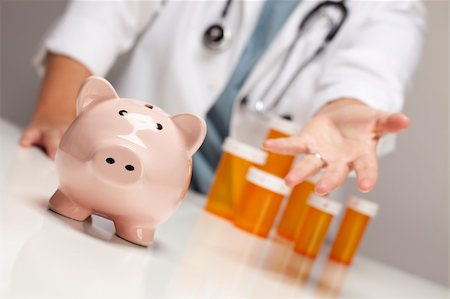 simsearch:400-04758612,k - Doctor Wearing Stethoscope Reaches Palm Out Behind Medicine Bottles and Piggy Bank. Stock Photo - Budget Royalty-Free & Subscription, Code: 400-05696391