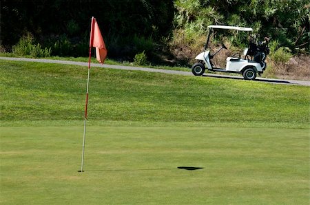 simsearch:400-04942072,k - Golf cart next to a hole on a golf course Foto de stock - Royalty-Free Super Valor e Assinatura, Número: 400-05690358