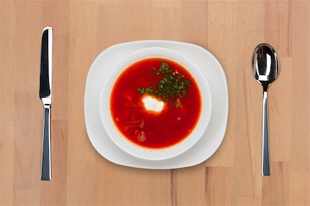 simsearch:400-09011310,k - A plate of traditional Russian red borsch with sour cream and greens on a wooden table with spoon and knife. Fotografie stock - Microstock e Abbonamento, Codice: 400-05690776