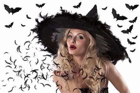 face shot of a cute and sexy girl dressed with a huge witch hat with feathers blowing a kiss Stock Photo - Budget Royalty-Free & Subscription, Code: 400-05692646