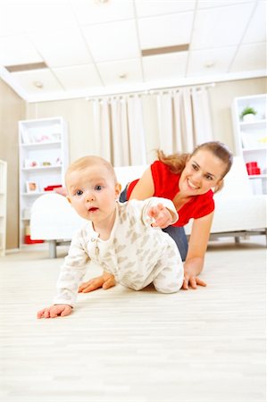 Smiling mommy playing with creeping on floor baby Stock Photo - Budget Royalty-Free & Subscription, Code: 400-05692895