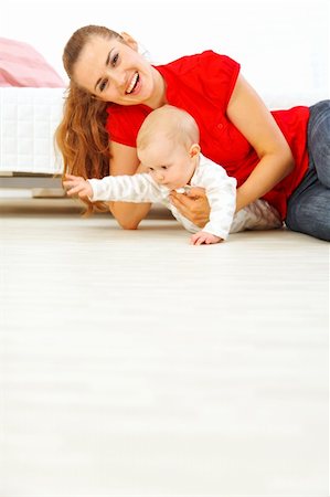 simsearch:400-05750410,k - Young mother and cheerful baby playing on floor Photographie de stock - Aubaine LD & Abonnement, Code: 400-05692891