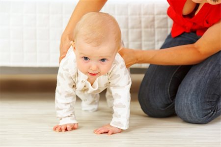 simsearch:400-05899075,k - Mother helping cheerful baby learn to creep Fotografie stock - Microstock e Abbonamento, Codice: 400-05692892