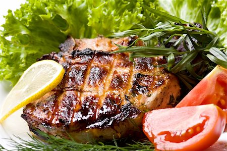 striped tomato - Grilled pork meat on plate with green salad Stock Photo - Budget Royalty-Free & Subscription, Code: 400-05693675
