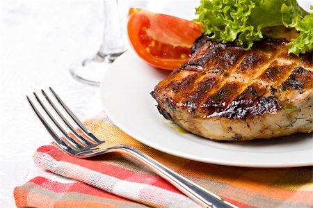 striped tomato - Grilled pork meat on plate with green salad Stock Photo - Budget Royalty-Free & Subscription, Code: 400-05693676