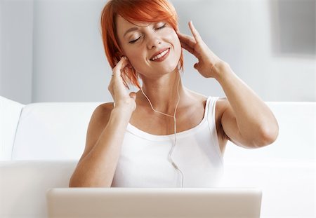 Caucasian redhead woman wearing headphones and listening music Photographie de stock - Aubaine LD & Abonnement, Code: 400-05704655