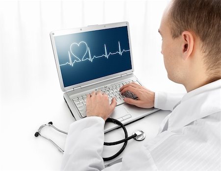 elettrocardiogramma - Rear view of a young doctor with laptop Fotografie stock - Microstock e Abbonamento, Codice: 400-05705486