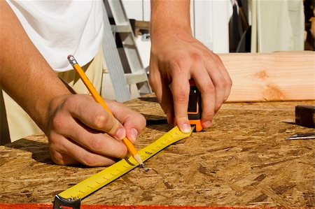 Closeup of a worker measuring a section of plywood. Stock Photo - Budget Royalty-Free & Subscription, Code: 400-05705676