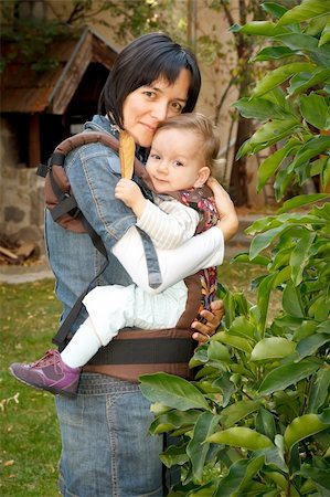 Mother carrying her lovely baby in sling, outside Foto de stock - Super Valor sin royalties y Suscripción, Código: 400-05705926